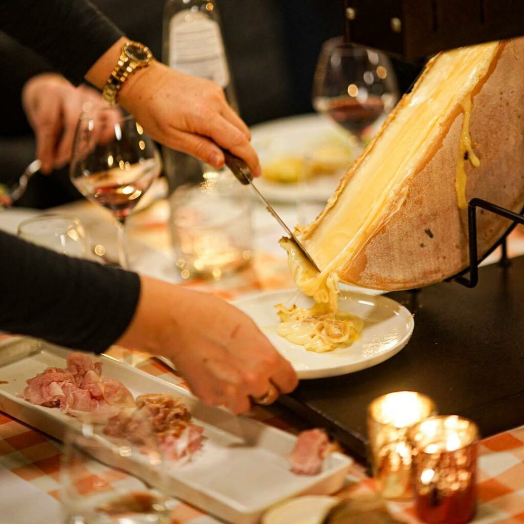 main se servant de la raclette sur table d'entreprise